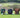 Three leather golf accessory pouches in green, black, and brown colors, displayed on a grass surface with golf balls beside them.