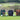 Three leather golf accessory pouches in green, black, and brown colors, displayed on a grass surface with golf balls beside them.